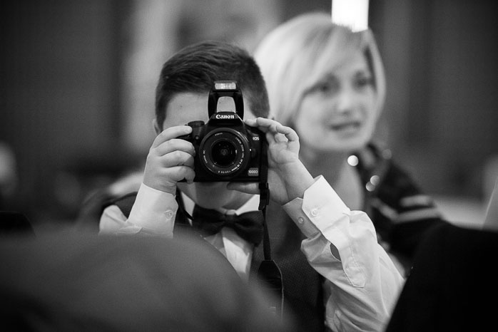 Il figlio degli sposi con una macchina fotografica.