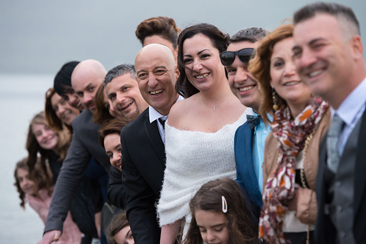 Sposi e amici sorridenti per una foto.