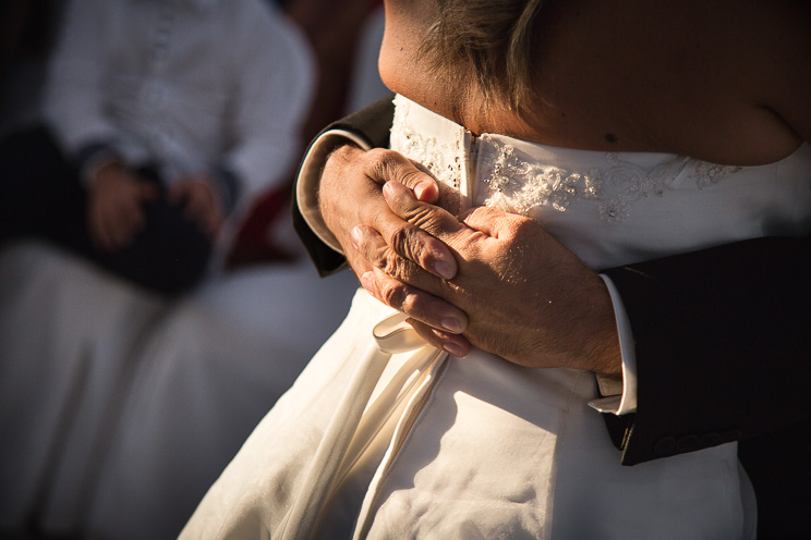 Le mani dello sposo stringono la sposa.